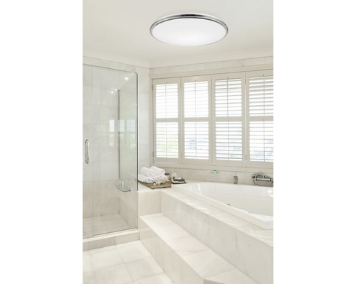 Moderná kúpeľňa so stropným kruhovým svietidlom, sprchou a vaňou.