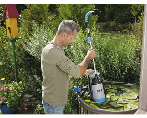Muž používa kalové čerpadlo do jazierka značky for.q v záhradnom jazierku