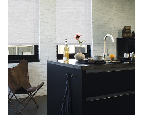 Svetlá kuchyňa s dvomi roletami na oknách, čiernym kuchynským ostrovčekom a koženou stoličkou