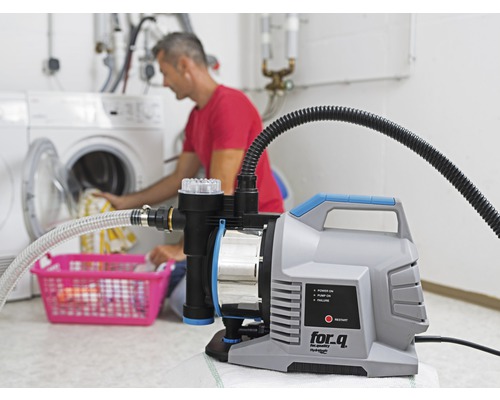 Domáca vodáreň používaná v práčovni s osobou, ktorá dáva bielizeň do práčky