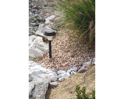 Záhradná scéna s okrasným štrkom a solárnym svetlom