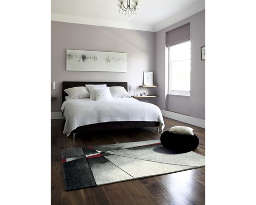 Spálňa s posteľou, kobercom a dekoráciou v modernom dizajne