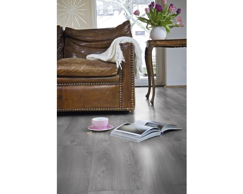 Obývacia izba s koženou sedačkou, stolom, tulipánmi a laminátovou podlahou.