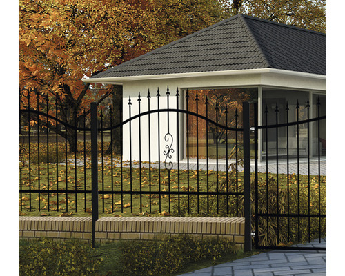 Ozdobný kovový plot pred domom s jesenným lístím