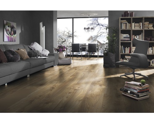 Obývacia izba s laminátovou podlahou, pohovkou, knižnicou a oknom so zimnou krajinou