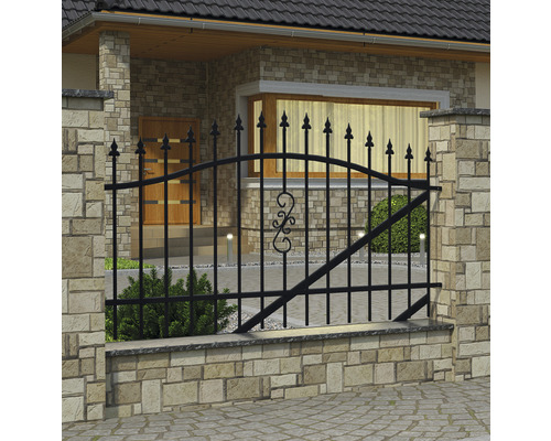 Čierny kovový plot pred domom s kamennou stenou