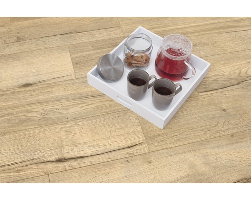 Svetlá drevená podlaha s bielym podnosom, čajníkom, dvoma šálkami a dózou na sušienky