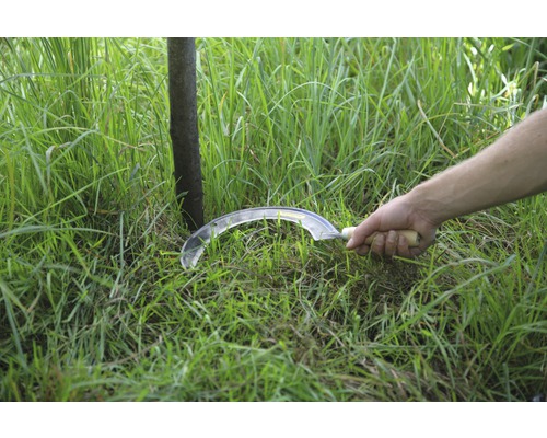 Ručná kosa s drevenou rukoväťou kosí trávu