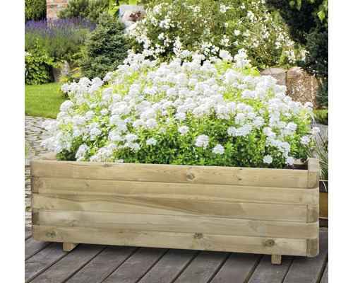 Drevený kvetináč s bielymi kvetmi v záhrade