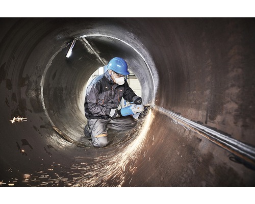 Kovoroľník opracováva zvar v rúre uhlovou brúskou