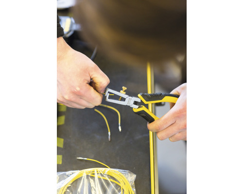 Osoba používa odizolovacie kliešte na žltý kábel.