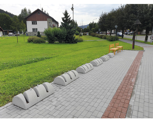 Betónový stojan na bicykel SK 2-3 prírodný tryskaný Vonkajšia fotografia s betónovým stojanom na bicykle na dláždenej ceste v parku.