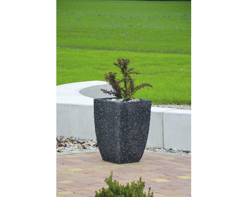 Štvorcový kamenný kvetináč s rastlinou v záhrade