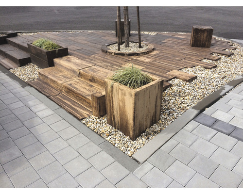 Upravený vonkajší priestor s dlažobnými kockami, drevenou terasou a výsadbou