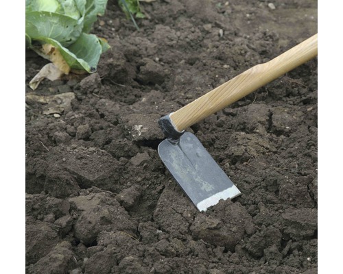 Záhradná motyka s drevenou rukoväťou v záhone