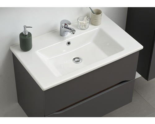 Umývadlo so skrinkou a batériou v kúpeľni.