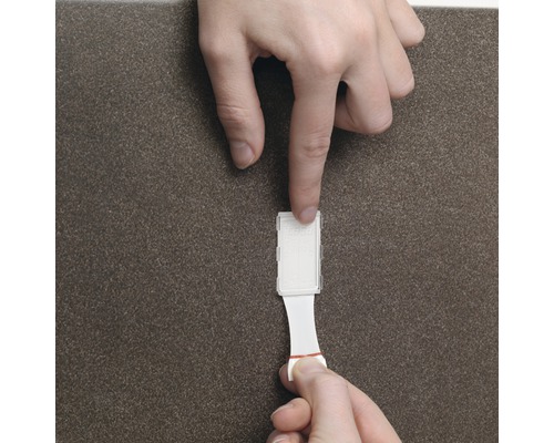 Osoba pripevňuje lepiaci háčik na povrch.