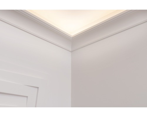 Pohľad na stenu a strop s ozdobnými lištami a nepriamym osvetlením