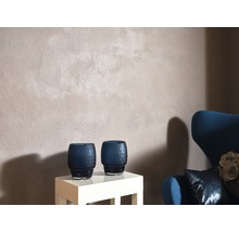 Obývacia izba so stenou s hrubou omietkou, dvoma dekoratívnymi vázami a kreslom