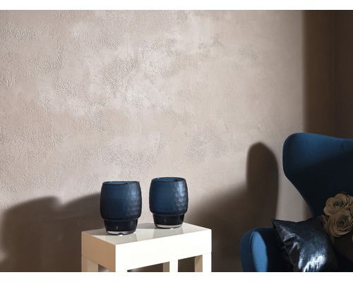 Obývacia izba so stenou s hrubou omietkou, dvoma dekoratívnymi vázami a kreslom