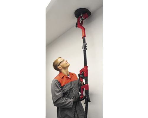 Muž používa brúsku na strop na brúsenie stropu.