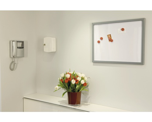 Scéna s magnetickou tabuľou, telefónom, trezorom na kľúče a kyticou kvetov