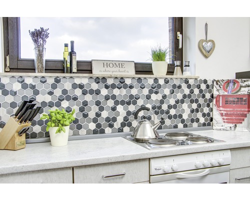 Kuchynská scéna s mozaikovými dlaždicami v tvare šesťuholníkov, sporákom a kuchynským náčiním.