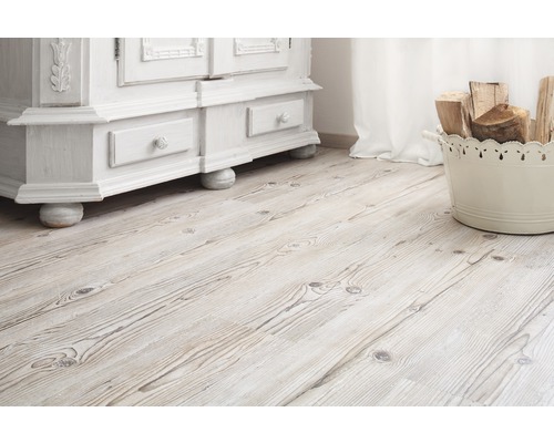 Svetlá drevená podlaha s bielou skriňou a košom s drevom