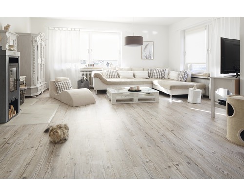 Svetlá obývacia izba s pohovkou, konferenčným stolíkom z paliet, krbovými kachľami a drevenou podlahou