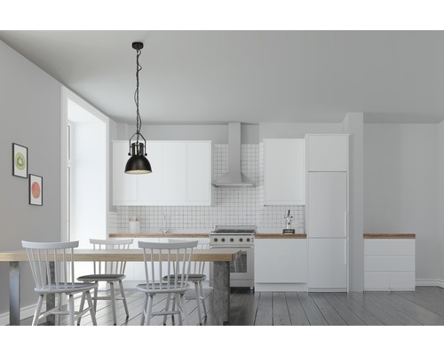 Jedáleň s jedálenským stolom, stoličkami a závesnou lampou v svetlej kuchyni.