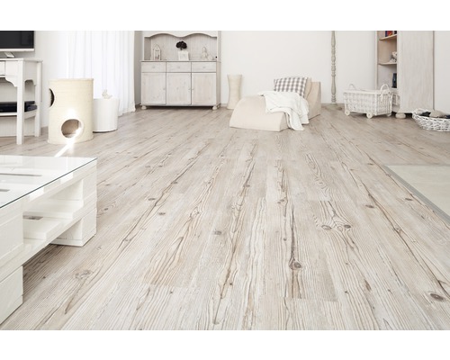 Svetlá obývacia izba s drevenou podlahou a bielym nábytkom.