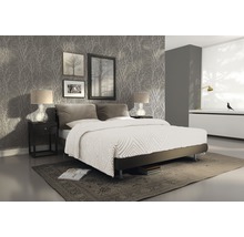 Spálňa s manželskou posteľou, nočným stolíkom, lampami, obrazmi a tapetou so vzorom