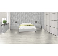 Svetlá spálňa s posteľou, nočnými stolíkmi, tapetou so vzorom stromu a šatníkovou skriňou