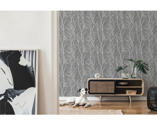 Obývacia izba so sivou tapetou so stromovým dizajnom, komodou a psom