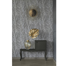 Dekoratívna scéna so vzorovanou tapetou, zrkadlom, vázou, listom a skrinkou na stole