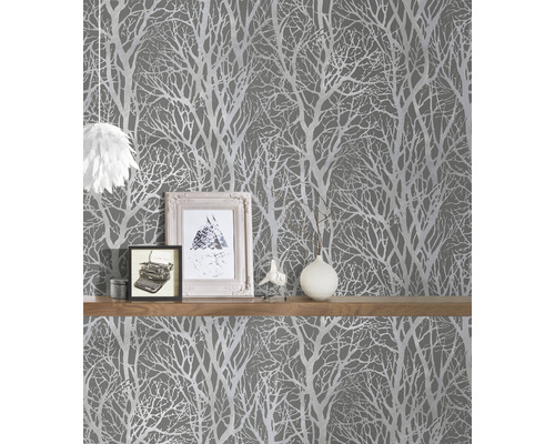 Scéna so sivou tapetou so vzorom stromu a policou s dekoráciami.