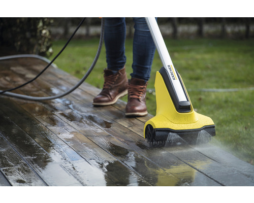 Osoba čistí drevenú terasu pomocou čističa terás Kärcher