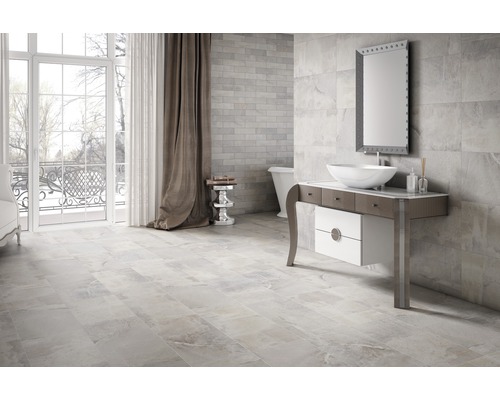 Svetlá kúpeľňa s dlažbou, umývadlovou skrinkou a zrkadlom