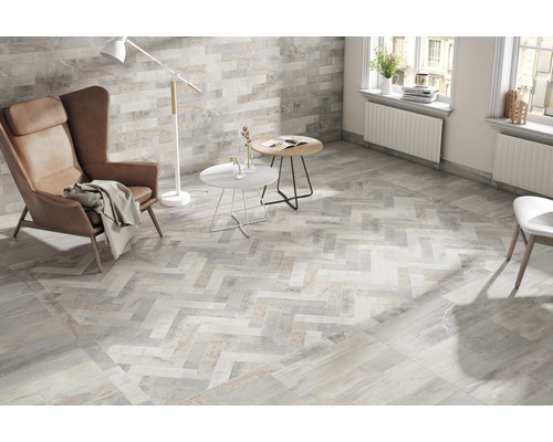 Svetlá obývacia izba s dlažbou so vzorom rybej kosti, kreslom a stojacou lampou