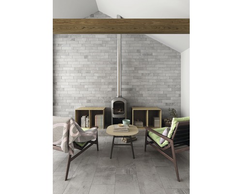 Obývacia izba s kamennou stenou, kachľami, drevenými trámami a posedením