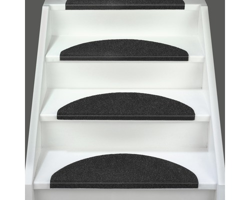 Schodisko s čiernymi stupnicovými rohožami na zníženie hluku a väčšiu bezpečnosť.