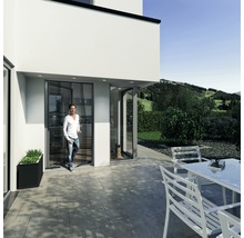 Moderná fasáda domu s terasovými dverami a mužom vchádzajúcim do domu