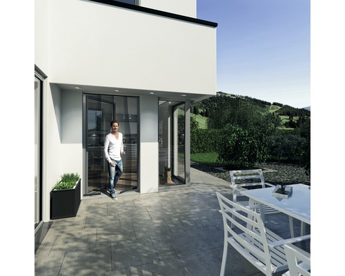 Moderná fasáda domu s terasovými dverami a mužom vchádzajúcim do domu