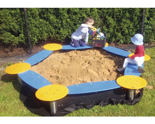 Pieskovisko so sedacími prvkami a hrajúcimi sa deťmi v záhrade