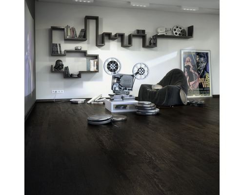 Obývacia izba s tmavou drevenou podlahou, projektorom, knižnicou a filmovým plagátom