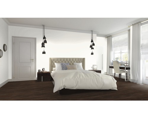 Spálňa s posteľou, nočnými stolíkmi, lampami a pracovným priestorom pri okne.