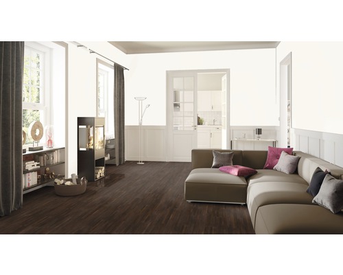 Obývacia izba s pohovkou, krbovými kachľami, knižnicou a drevenou podlahou.