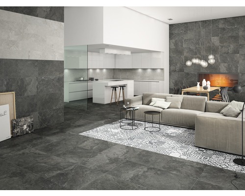 Obývacia izba s podlahovými a nástennými dlaždicami v kamennom vzhľade, pohovka a otvorená kuchyňa