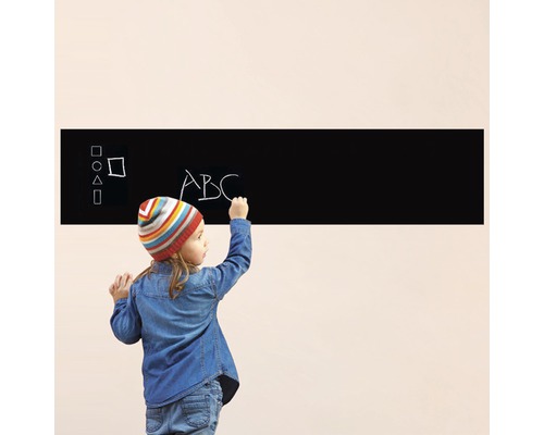 Dieťa píše na samolepiacu tabuľu na stenu