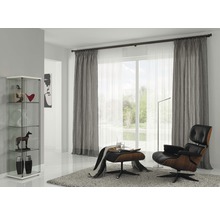 Obývacia izba s vitrínou, závesmi, kreslom a kobercom pre útulnú atmosféru